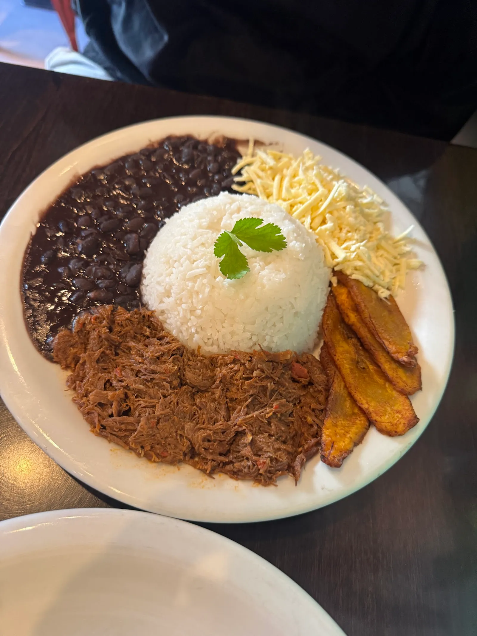 Pabellón criollo: carne mechada, arroz, caraotas negras, queso y tajadas